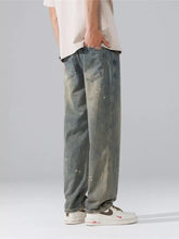Men’s wide leg jeans in washed denim with a faded blue wash and white paint splatter details