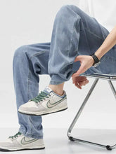 White nike dunk low sneakers with green laces and accents paired with men’s wide leg jeans for casual wear
