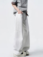 Men’s wide leg jeans in white denim with relaxed fit and visible stitching detailing on front and sides