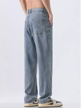 Back side of men’s wide leg light-wash denim jeans with a relaxed straight-leg cut and a triangular brand patch
