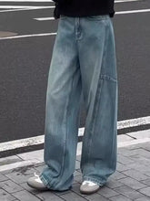 Men’s light-wash denim jeans with a wide-leg cut and visible stitching details for a relaxed fit