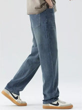 Men’s blue denim wide leg jeans with pockets featuring a relaxed straight-leg cut and subtle fading