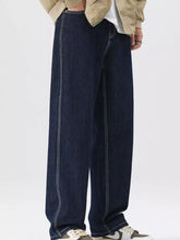 Men’s wide leg jeans in dark blue denim with white stitching along the seams and functional pockets