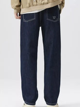 Dark blue wide leg jeans with white stitching and a small triangular logo on the back pocket shown from the back side