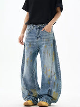 Men’s wide leg denim jeans with faded blue wash and yellow paint splatter design for casual wear
