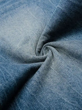 Close-up texture of light blue distressed mens wide leg relaxed fit denim shorts