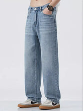 Men’s light-wash denim jeans with a relaxed fit and wide leg cut featuring subtle fading along the thighs
