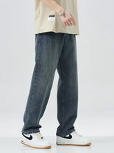 Men’s dark-wash denim relaxed fit jeans with a wide leg and subtle fading details in a straight-leg cut