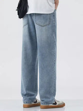 Men’s light-wash denim jeans with a relaxed fit and wide leg featuring classic stitching details