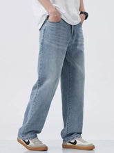 Men’s light-wash denim jeans with a relaxed fit and wide leg featuring classic stitching details