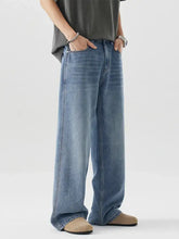 Men’s wide leg relaxed fit jeans in medium-wash blue denim with classic stitching and a relaxed fit design