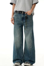 Men’s wide leg denim jeans in faded blue vintage wash with subtle distressing details