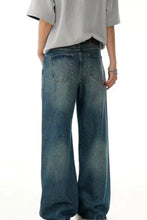 Men’s wide leg vintage wash jeans in faded blue denim with subtle whiskering and reinforced stitching
