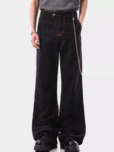 Men’s wide leg wash jeans in black denim with red stitching and a silver chain on the side pocket