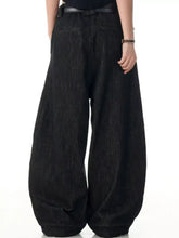 Men’s black wide leg wash jeans with a relaxed flowing silhouette and subtle textured denim fabric