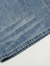 Men’s wide leg wash jeans in light-wash denim with subtle fading and visible stitching along the hem