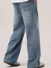 Men’s wide leg wash jeans in light-wash denim with relaxed wide leg cut and classic back pockets shown from the back
