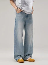 Men’s wide leg wash jeans in light-wash denim with a relaxed fit and subtle distressed details