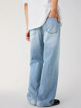 Men’s wide leg wash jeans in light-wash denim with a wide-leg cut and classic back pockets showing the back side