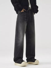 Men’s black wide leg washed jeans with faded distressed finish and visible stitching along the seams