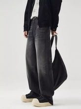 Men’s black wide leg washed jeans with faded denim and visible stitching details in a wide leg design