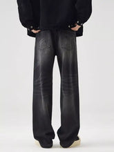Men’s wide leg washed jeans in black with faded distressed finish and classic back pockets shown from the back side