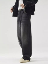Men’s black wide leg washed jeans with relaxed tapered fit and subtle fading details in denim fabric