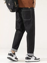 Men’s wide leg dark-wash denim jeans with contrasting white stitching and rolled cuffs in a casual style