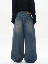 Men’s wide leg washed jeans in faded blue denim with a relaxed baggy fit and visible stitching details