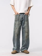 Men wide leg washed jeans in faded blue denim with distressed paint-splatter detailing and wide leg cut