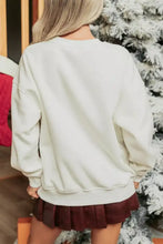 Cream-colored oversized crewneck sweatshirt with merry bow graphic, relaxed fit, ribbed cuffs, and machine wash care
