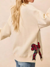 Back view of cream-colored merry bow slit crew neck sweatshirt with red green plaid bow appliqué in slightly stretchy material suitable for machine wash cold