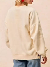 Cream-colored MERRY Bow Slit Crew Neck Christmas sweatshirt with relaxed fit ribbed cuffs and slightly stretchy material