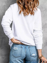 White long-sleeved merry christmas graphic sweatshirt with ribbed cuffs and relaxed fit machine wash cold