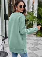 Merry Christmas graphic sweatshirt in mint green with long sleeves and side slits