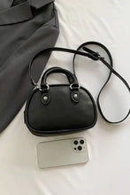 Black leather crossbody handbag with silver hardware and round shape