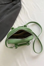 Sage green leather handbag with frog charm and adjustable strap