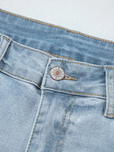 Mid rise ankle-length light-wash denim distressed skinny jeans with slight stretch and a circular metal jeans button