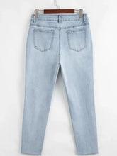 Light-wash mid rise ankle-length distressed skinny jeans with slight stretch and frayed hems in denim material