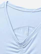 White v-neck active tank with ruched neckline and ribbed hem, machine wash cold