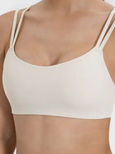 Cream-colored Millennia scoop neck racerback sports bra, machine wash cold