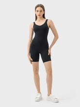 Millennia Wide Strap Active Romper: black seamless one-piece swimsuit with white sneakers, minimalist design