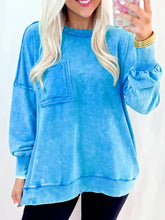 Mineral wash light blue distressed sweatshirt with puffed sleeves and front pockets featuring easy machine wash care instructions