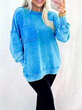 A soft vibrant blue mineral wash sweatshirt with raw seam double patched pocket and machine wash care instructions