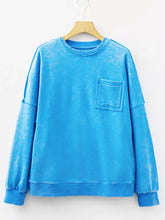 Bright blue mineral wash sweatshirt with soft texture, distressed pocket, ribbed cuffs, and machine wash care instructions