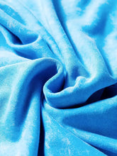A vibrant blue velvet mineral wash sweatshirt with plush texture featuring raw seams and double patched pockets, machine wash care instructions