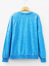 A vibrant blue mineral wash cotton sweatshirt with a relaxed fit, ribbed cuffs, and machine wash care instructions