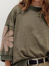 Olive green mineral wash oversized sweatshirt with raw seam patchwork and pink embroidered flower on sleeve