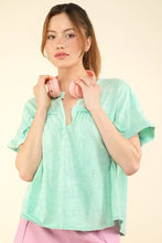 Mint green ruffled V-neck blouse in washed knit fabric with notched short sleeve