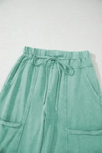 Mint green wide-leg cargo pants with drawstring waist and pockets